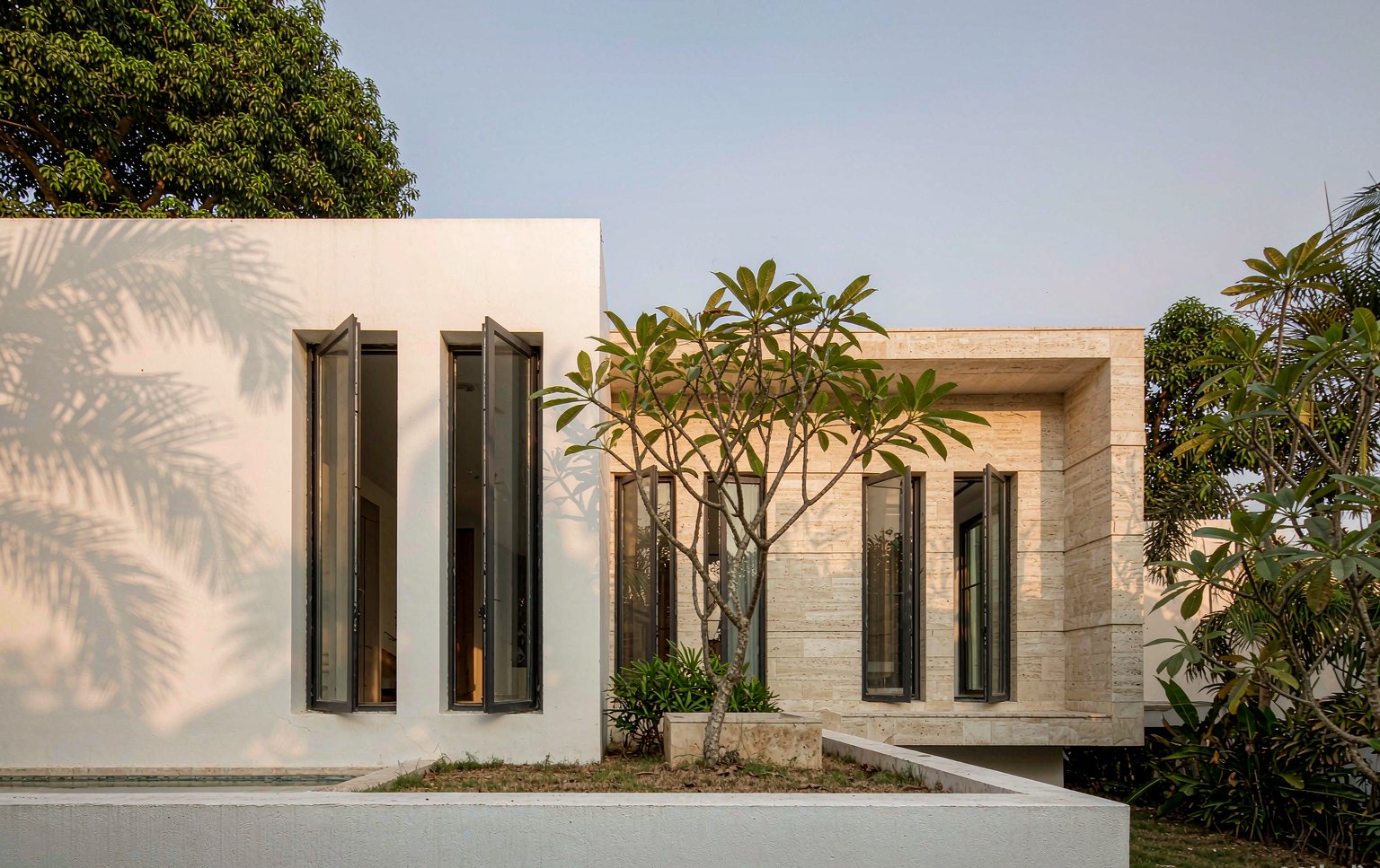 White villa facade with slim black aluminum windows in daylight